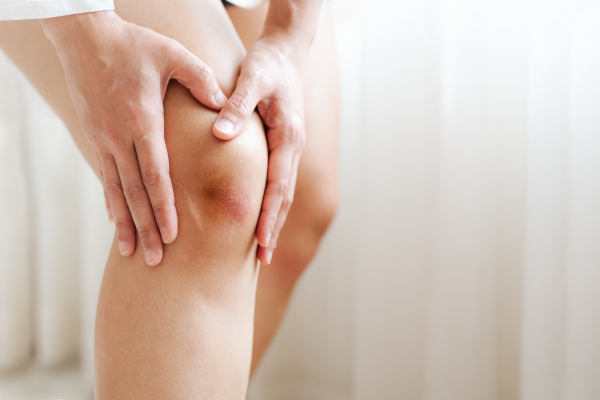 Person holding knee in pain or discomfort